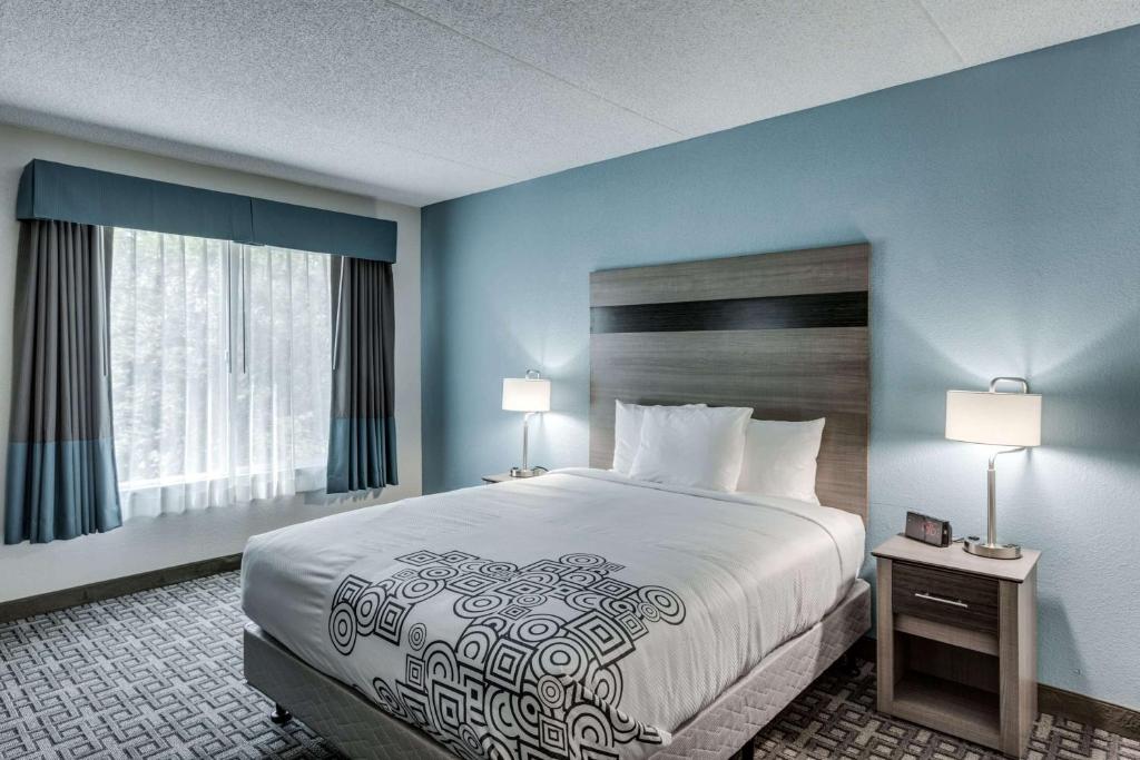 斯波坎Days Inn & Suites by Wyndham Spokane的酒店客房设有一张大床和两盏灯。