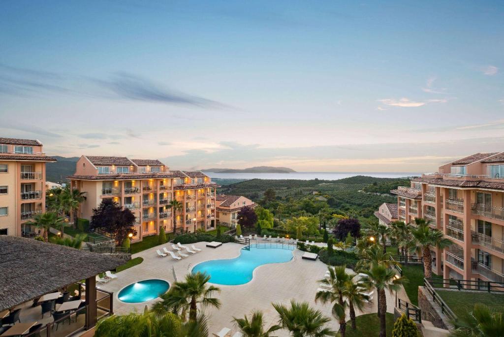 库萨达斯Wyndham Residences, Kusadasi Golf & Spa的享有带游泳池的度假村的空中景致