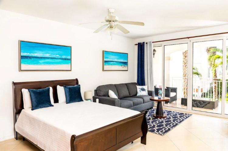 Turtle CoveLa Vista Azul - Lovely Spacious Condo close to Grace Bay - Free Wi-Fi的一间卧室配有一张床,客厅配有沙发