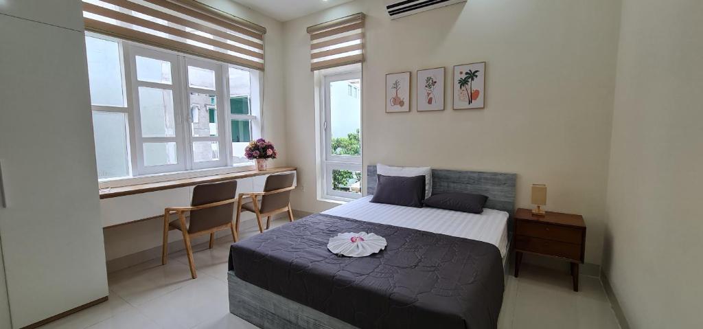 头顿Châu Gia Villa Vũng Tàu - Có chỗ đậu xe hơi的卧室配有一张床、一张书桌和窗户。
