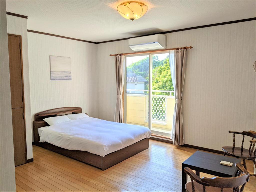 壹岐市ritomaru house iki ashibe的一间卧室设有一张床和一个大窗户