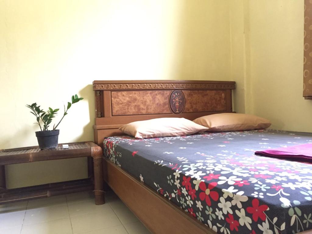 日惹加瑟尔民宿的一间卧室配有一张床和一张植物桌子