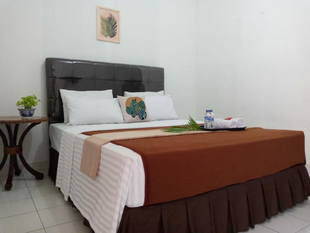 TimuranNew Hotel Kayu Manis的一间卧室配有一张大床和一张桌子