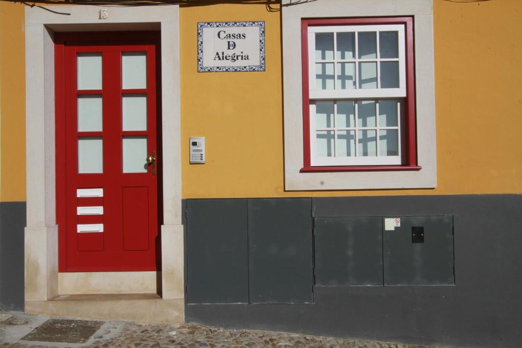 科英布拉欢乐之家的一座红色门和窗户的建筑
