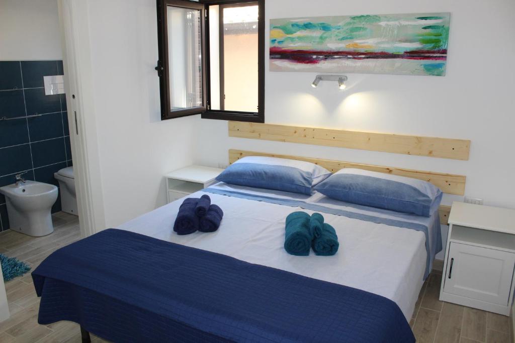 阿雷内拉Anthiros Affitti brevi的一间卧室配有一张带两个蓝色拖鞋的床
