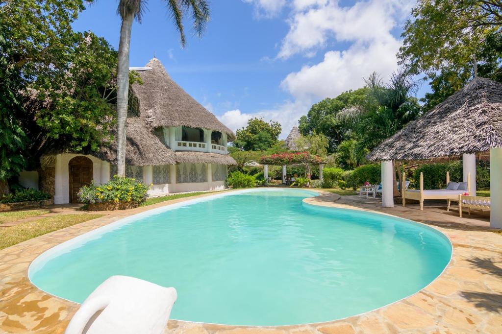 马林迪Peponi Villa Malindi的一座带房子的度假胜地的游泳池