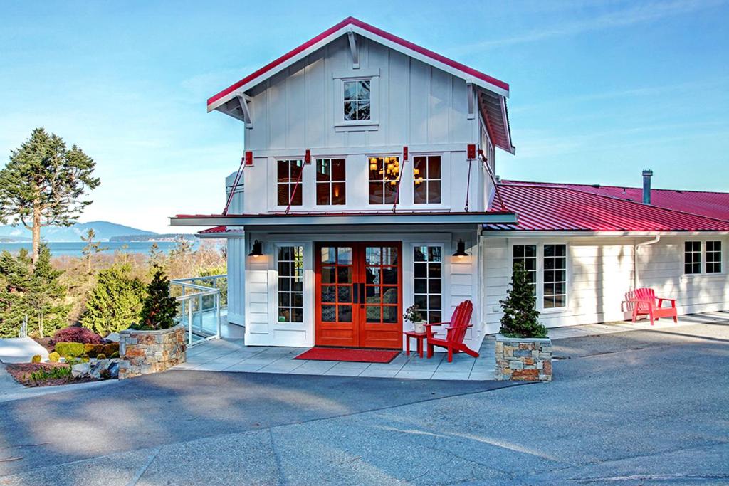 安娜柯蒂斯阿纳科特斯船舶港口酒店的白色的房子,有红色的门和红色的椅子