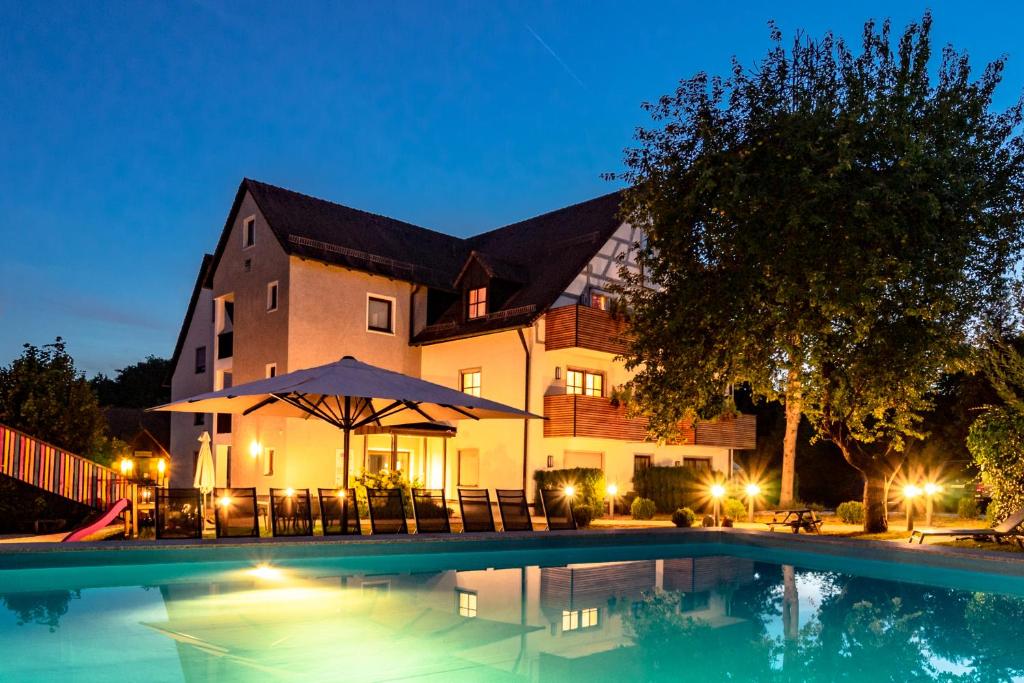 欧波楚巴赫弗瑞迪瑞克斯霍夫家庭酒店的一座在晚上设有游泳池的大房子