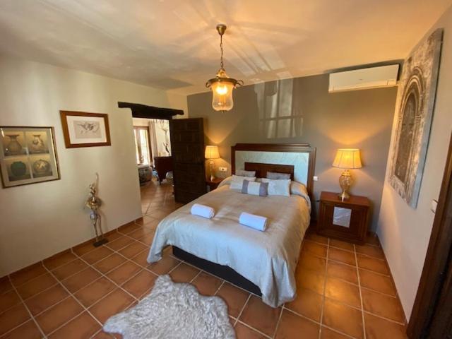 Ermita NuevaLuxury Spanish Country House close to Granada & Sierra Nevada的卧室设有一张大床,铺有瓷砖地板。
