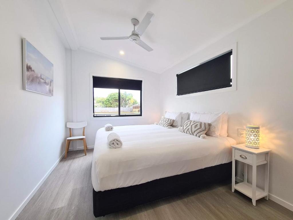 拜伦湾Club Byron Accommodation的白色的卧室设有一张大床和一个窗户