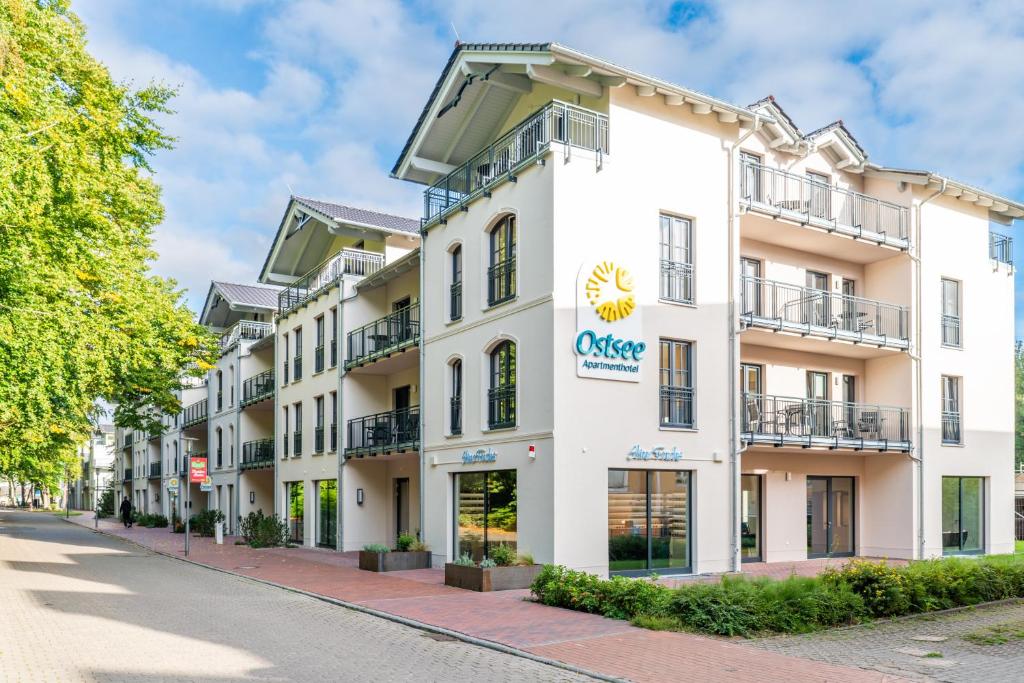 格拉尔-米里茨Ostsee Apartmenthotel的一座白色的大建筑,上面有太阳标志