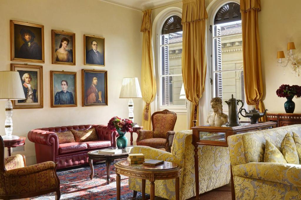 佛罗伦萨佩蒂尼酒店的客厅配有沙发和墙上的画像
