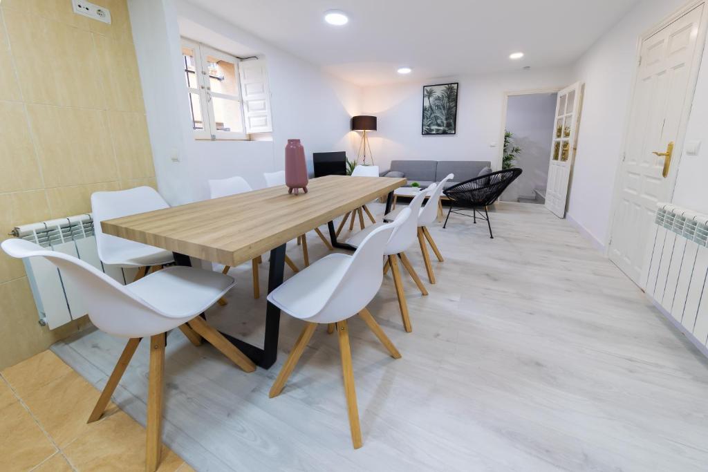 阿尔玛桑Casa San Román Soria的一间带木桌和白色椅子的用餐室