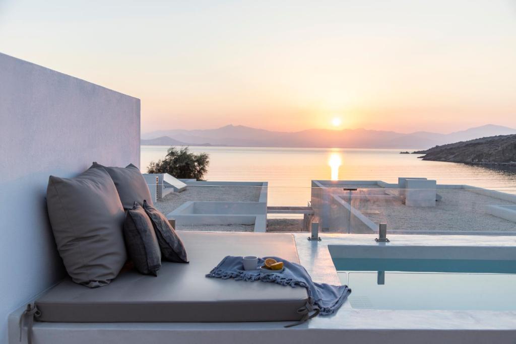 莫罗斯帕罗Citadela Paros Molos - Beachfront Maisonette with Plunge Pool的一张带枕头的沙发,享有日落美景