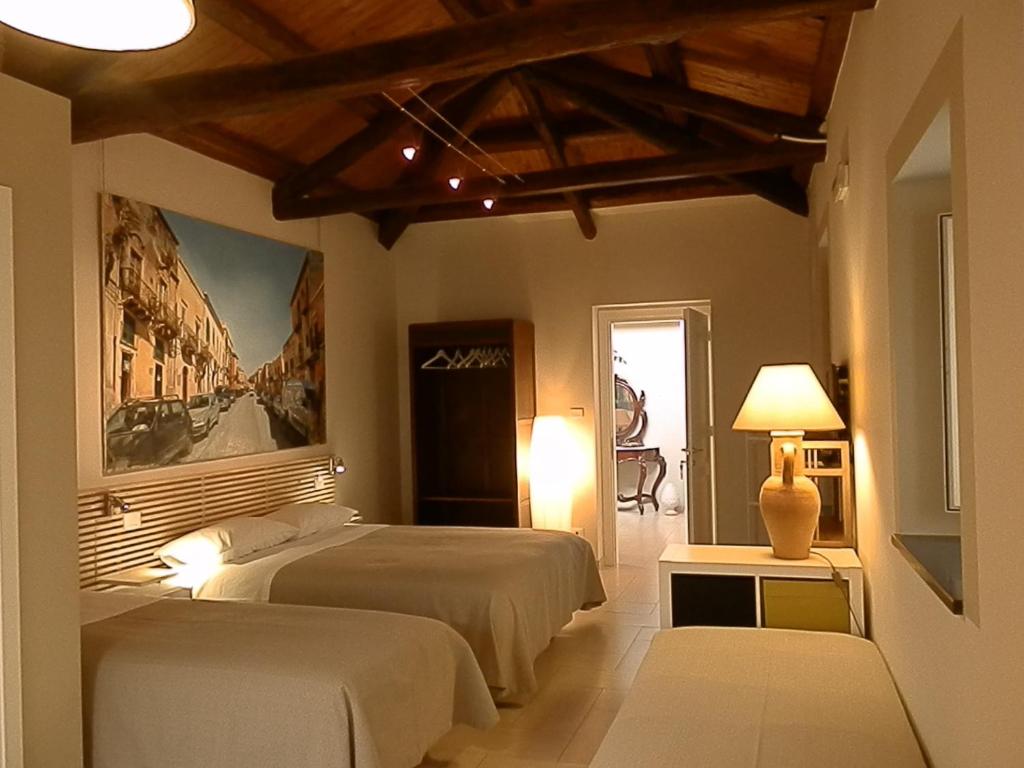 米拉佐翁贝托国王住宿加早餐酒店的一间卧室设有两张床,墙上挂着一幅画