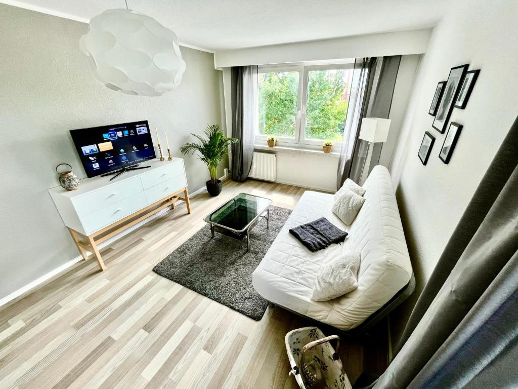 开姆尼茨KMHosting modern & gemütlich im Zentrum的客厅配有白色沙发和电视