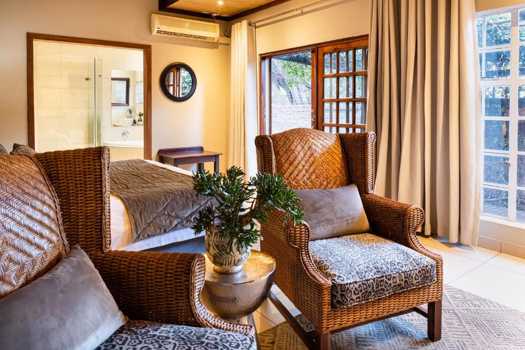卡图Kathu Gamagara Lodge的客厅配有藤椅和沙发