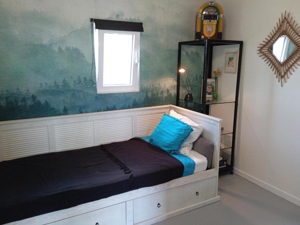 阿尔比Eden 122的一间卧室配有一张带蓝色枕头的床