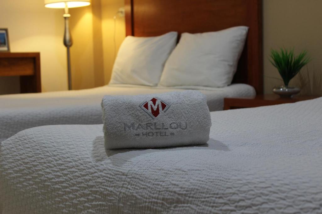贾拉普Hotel Marllou的酒店客房,配有一张白色的床,上面有毛巾