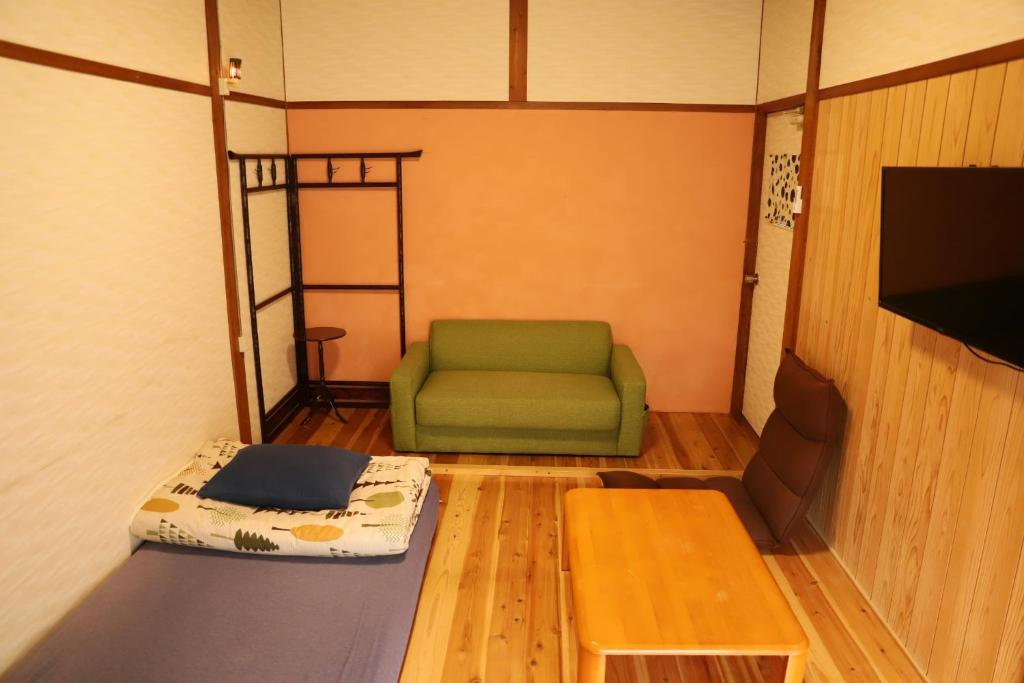 富士宫市Guesthouse TOKIWA - Vacation STAY 01074v的配有绿色椅子和桌子的房间