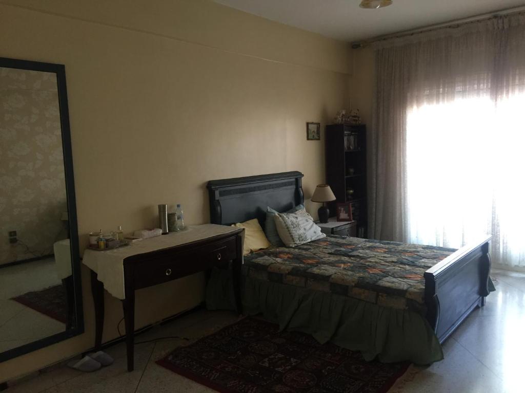 卡萨布兰卡Room in Guest room - Property located in a quiet area close to the train station and town的一间卧室配有一张床、一张书桌和一面镜子