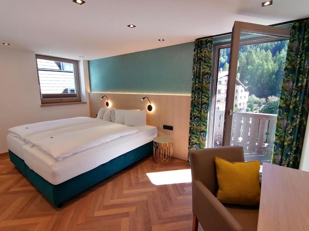 圣安东阿尔贝格豪斯马里昂豪额斯酒店的一间卧室设有一张大床和一个大窗户