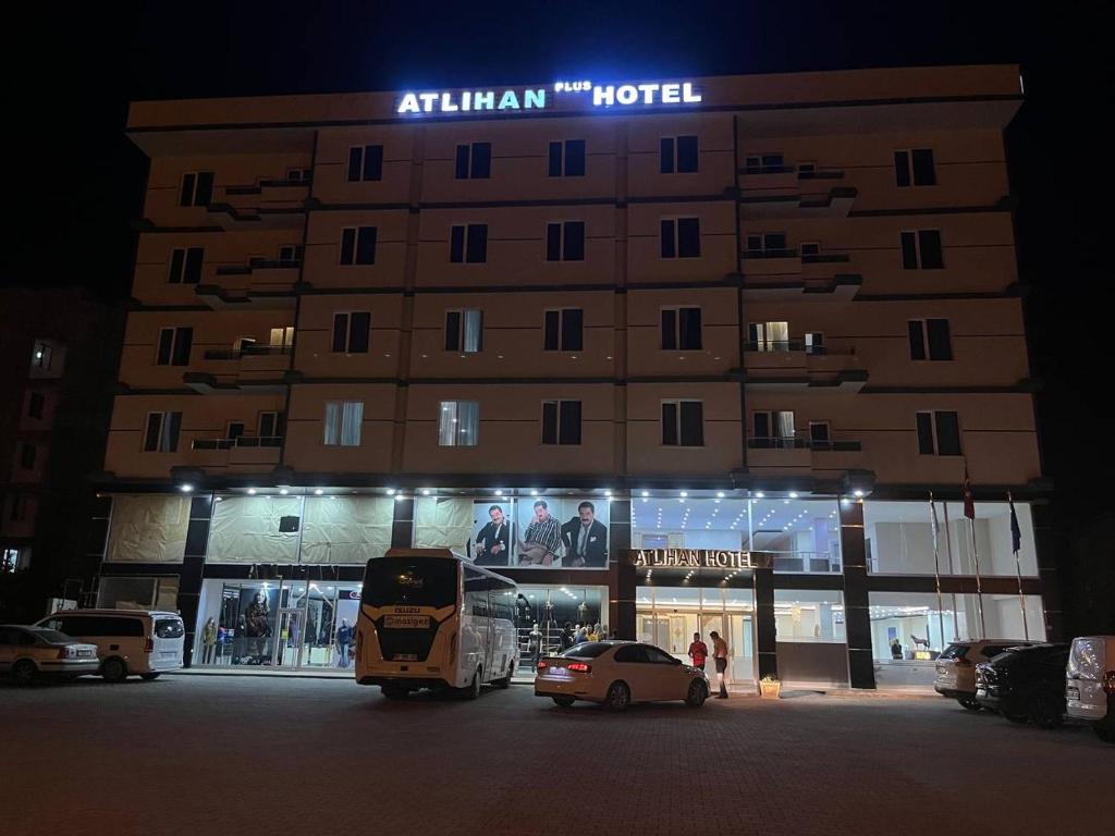 DoğubayazıtATLIHAN PLUS HOTEL的夜间酒店,门前有车辆停放