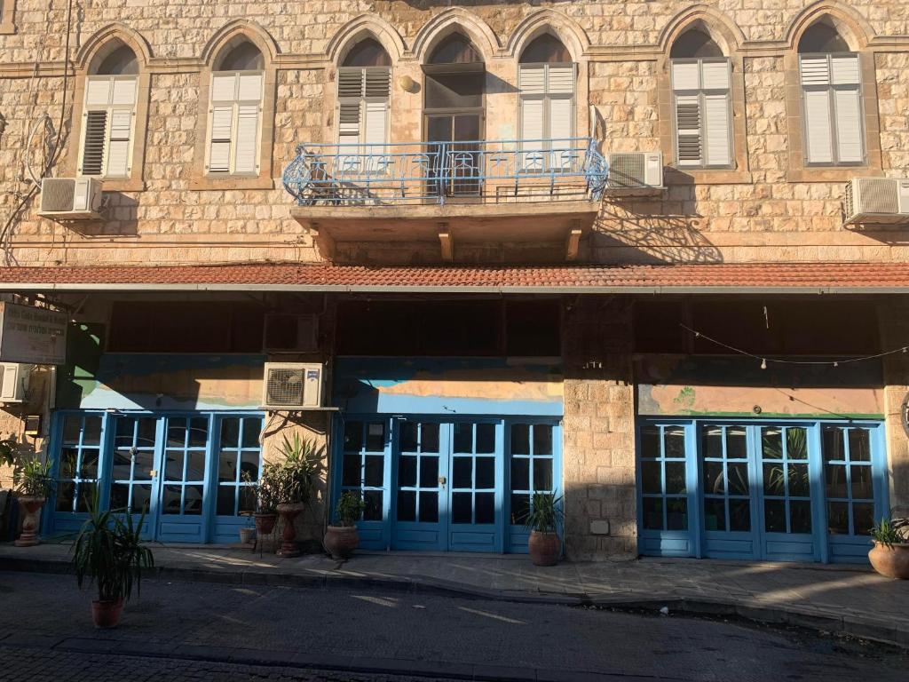 阿卡阿卡门旅馆 的一栋带蓝色门和阳台的建筑