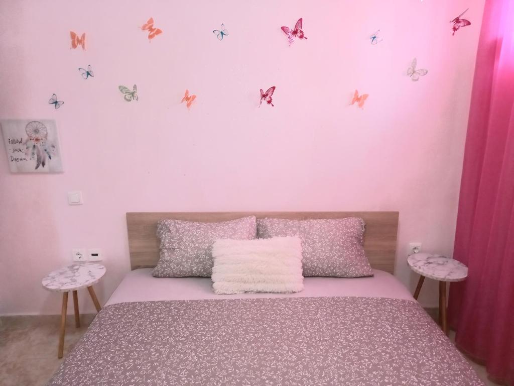塞雷PUZZLE SWEET HOME的一间卧室配有一张粉红色墙壁和墙上蝴蝶床。