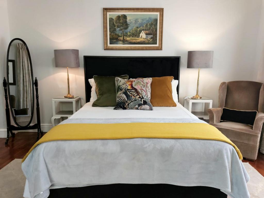 弗朗斯胡克Daisy Place的一间卧室配有一张带黄毯和椅子的床