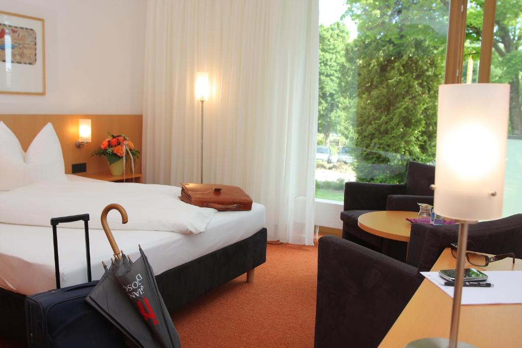 Aschau am Inn登博斯科酒店的酒店客房配有床、沙发和桌子。