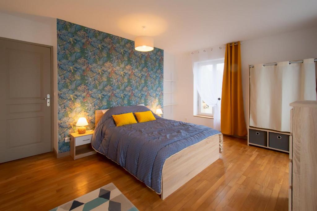 卢瓦尔河畔普伊Gîte des Chaumiennes的一间卧室设有一张床和蓝色的墙壁