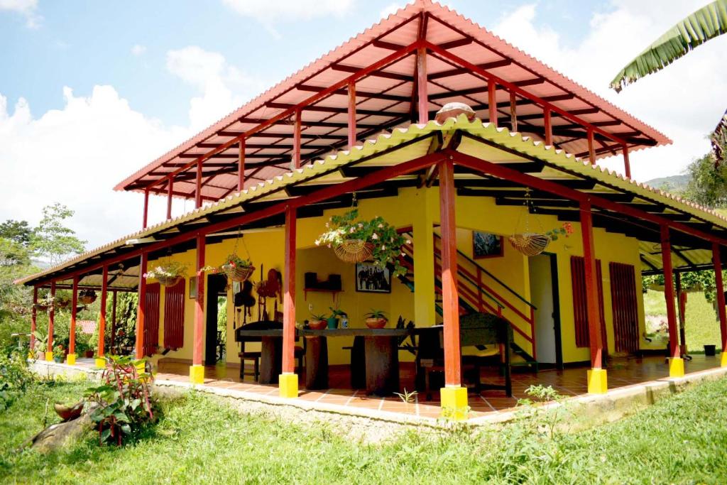 瓜杜阿斯Casa Campestre Villa del Lago的黄色的房屋,有红色的屋顶