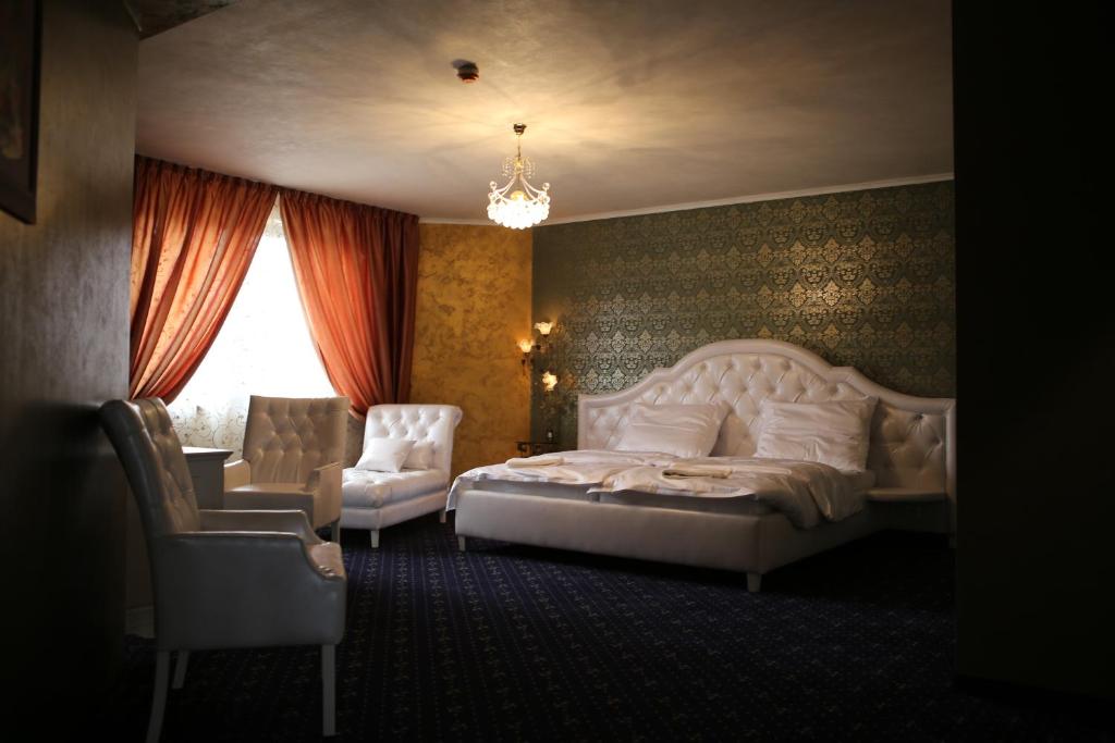 布拉迪斯拉发克托娃汽车旅馆的卧室配有白色的床和椅子