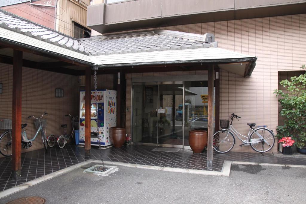 大阪Osaka Ryokan Kuramoto的两辆自行车停在大楼外