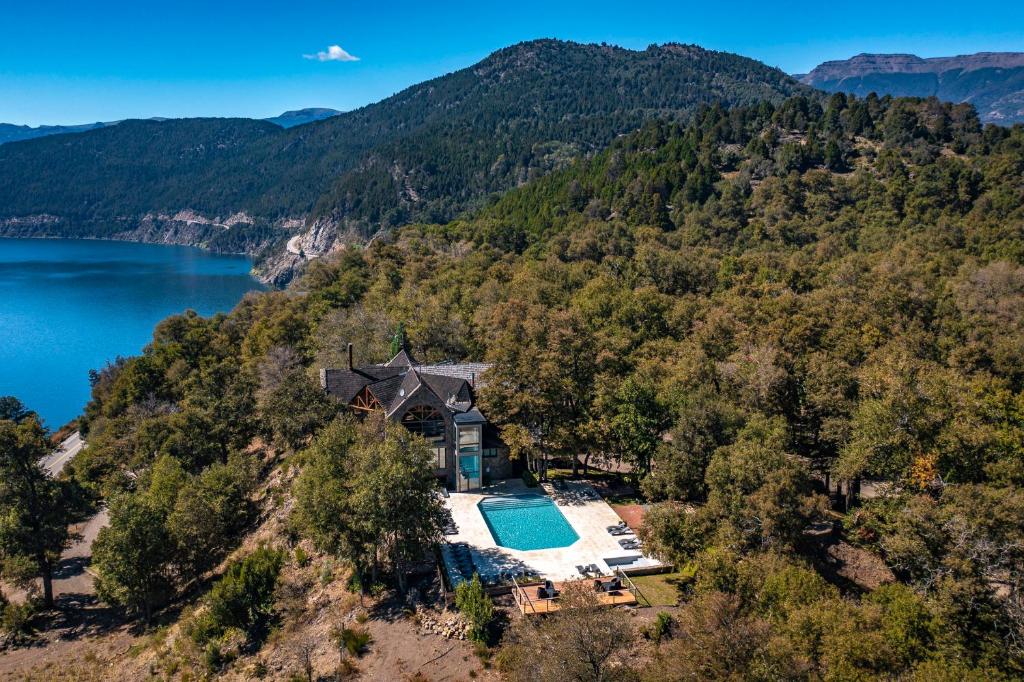 圣马丁德洛斯派胡恩-蒙塔纳度假酒店的享有山丘上房屋的空中景致,设有游泳池