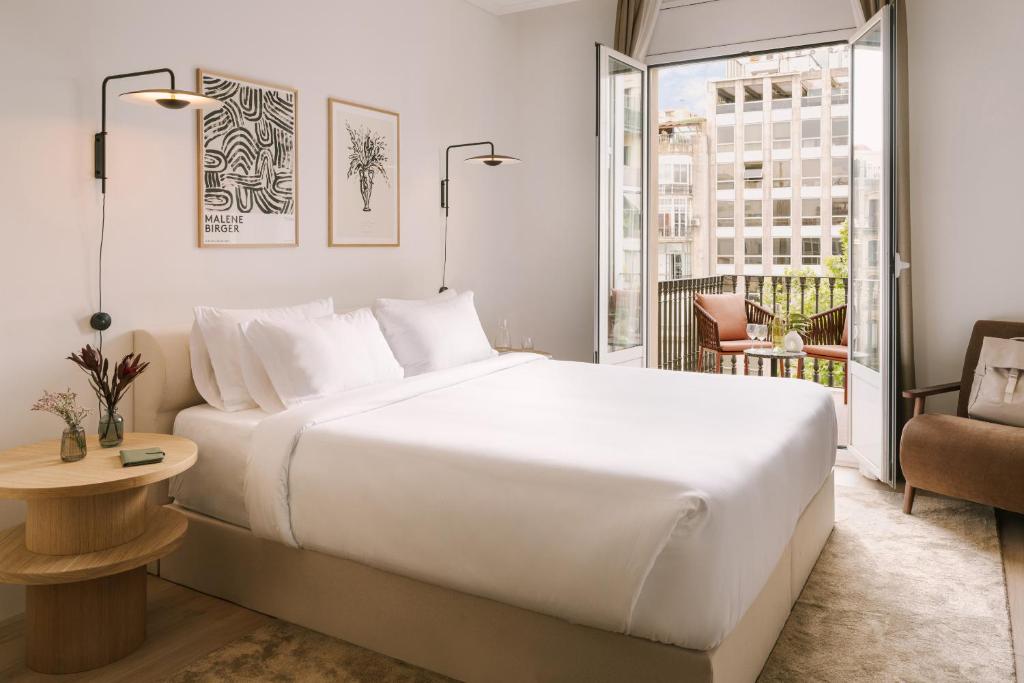巴塞罗那Sonder Paseo de Gracia的一间带一张白色大床的卧室和一个阳台