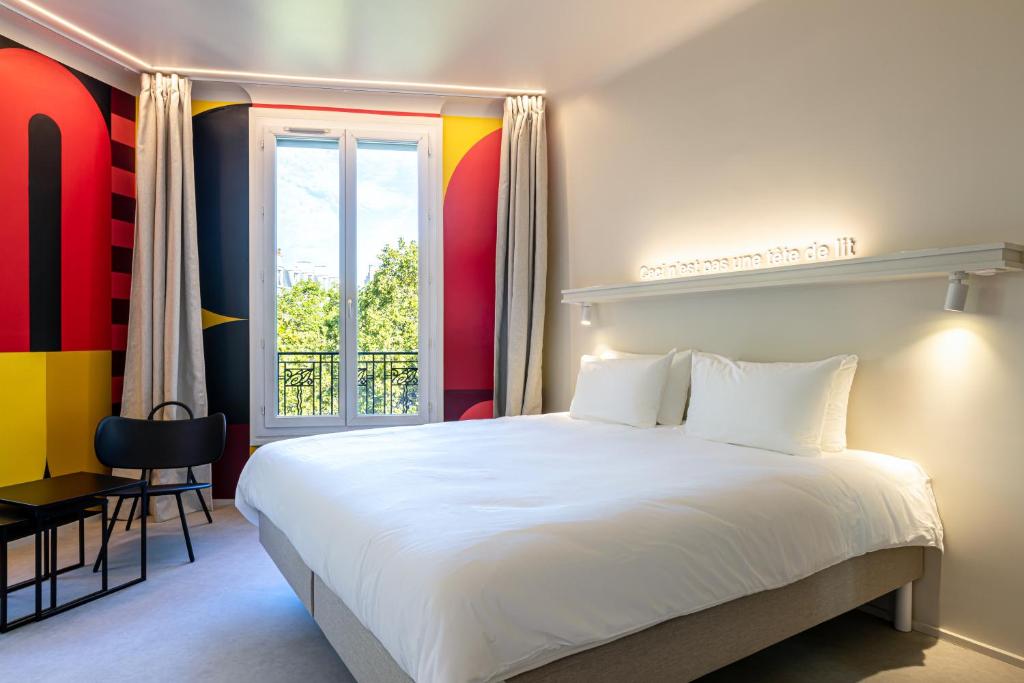 巴黎Graphik Montparnasse的卧室设有一张白色大床和一扇窗户。