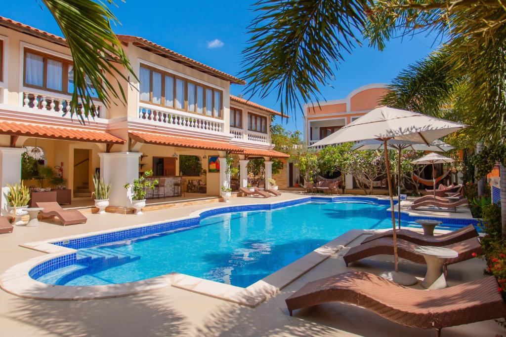 杰里科科拉Hotel Villa Beija Flor的别墅设有带椅子和遮阳伞的游泳池