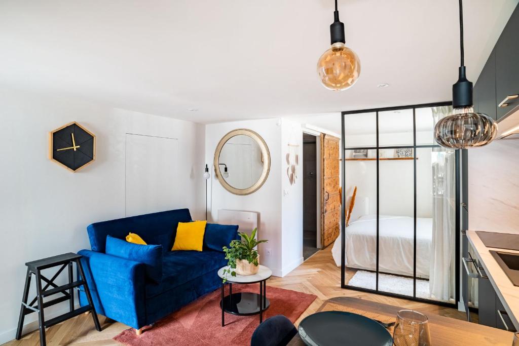 埃沙内韦Charmant Studio paisible dans le Centre du Village的一间带蓝色沙发的客厅和一间卧室