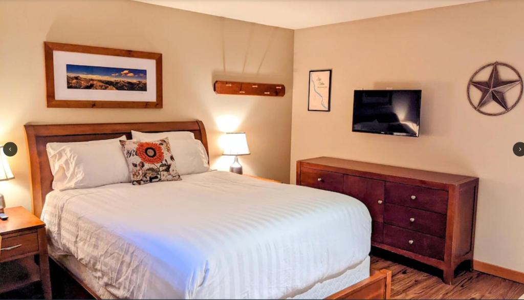 奇兰Driftin' Cabanas的卧室配有一张床,墙上配有电视。