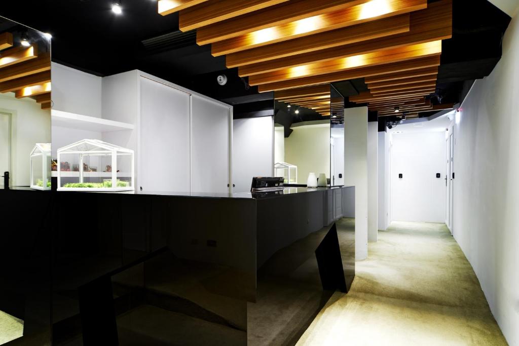 台北复新文旅的厨房设有黑色柜台和木制天花板。