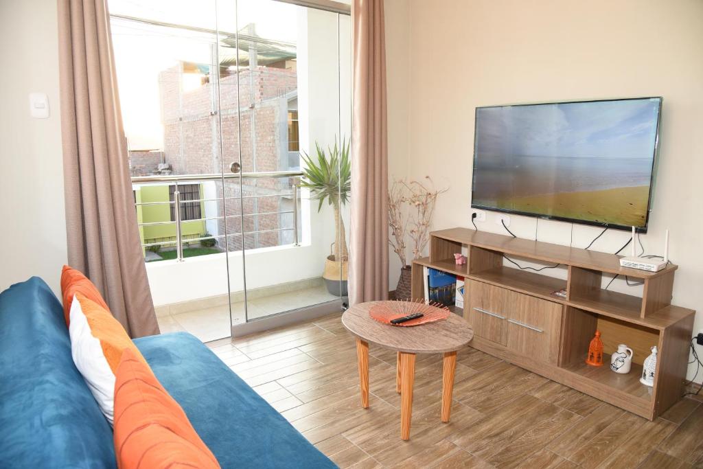 伊察Apartamento Hermoso en Residencial - Huacachina的客厅配有蓝色的沙发和平面电视。