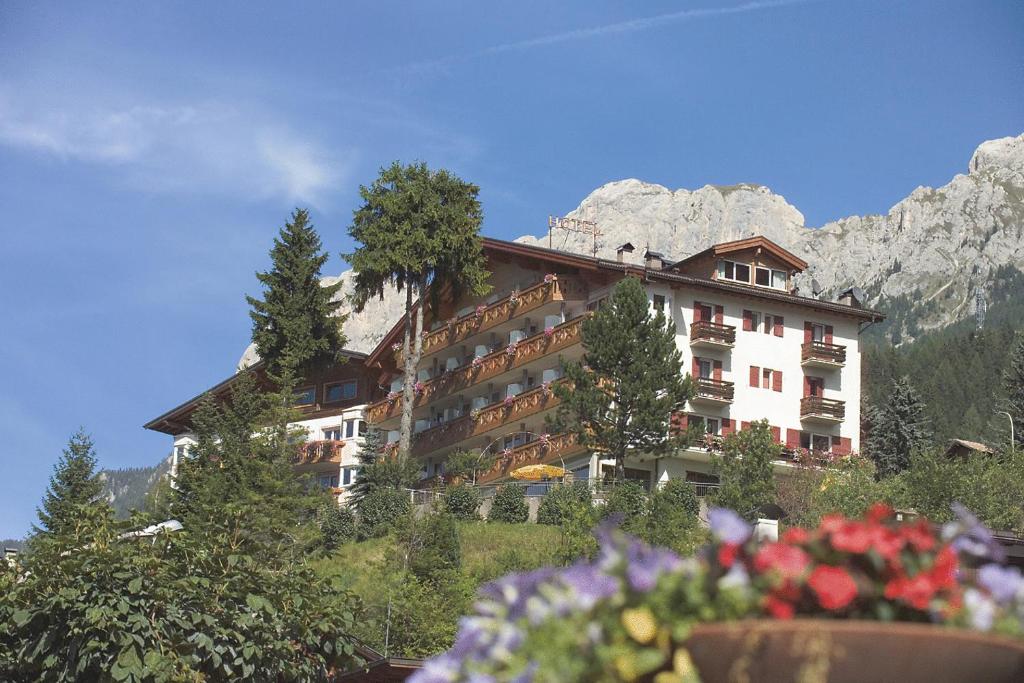 莫埃纳坎缇娜希翁玫瑰园酒店的山丘上的建筑,背景是山脉