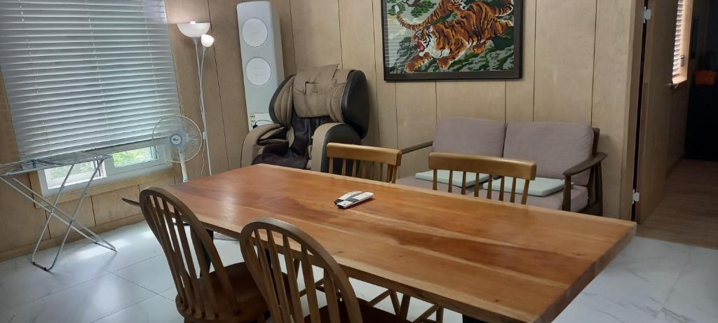 济州市Hamdeok pool villa pension的一间带木桌和椅子的用餐室