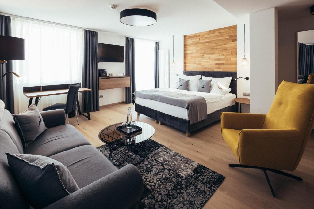 西兰德罗Genusshotel Goldene Rose的酒店客房,配有床和沙发