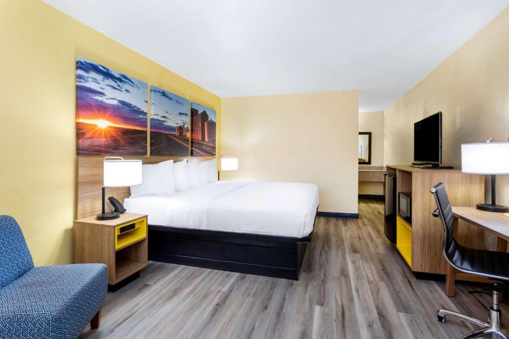 克洛维斯克洛维斯戴斯套房汽车旅馆的配有一张床和一张书桌的酒店客房