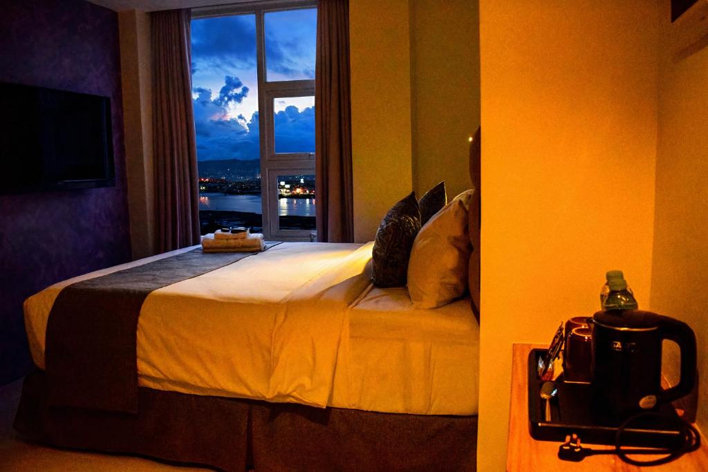 麦克坦Sempre Premier Inn - MACTAN AIRPORT HOTEL的一间卧室设有一张大床和窗户