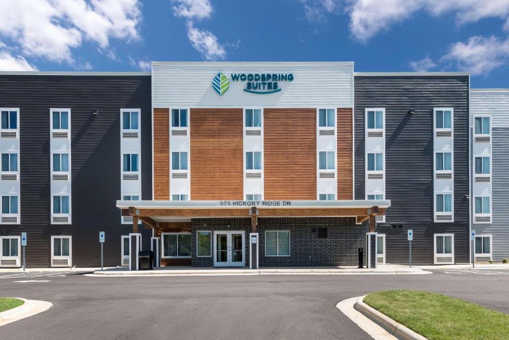 格林斯伯勒WoodSpring Suites Greensboro - High Point North的前面有标志的建筑