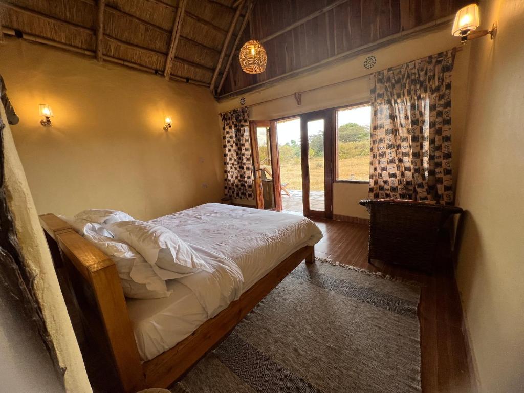 马赛马拉Olaloi Mara Camp的一间带床的卧室,位于带窗户的房间内